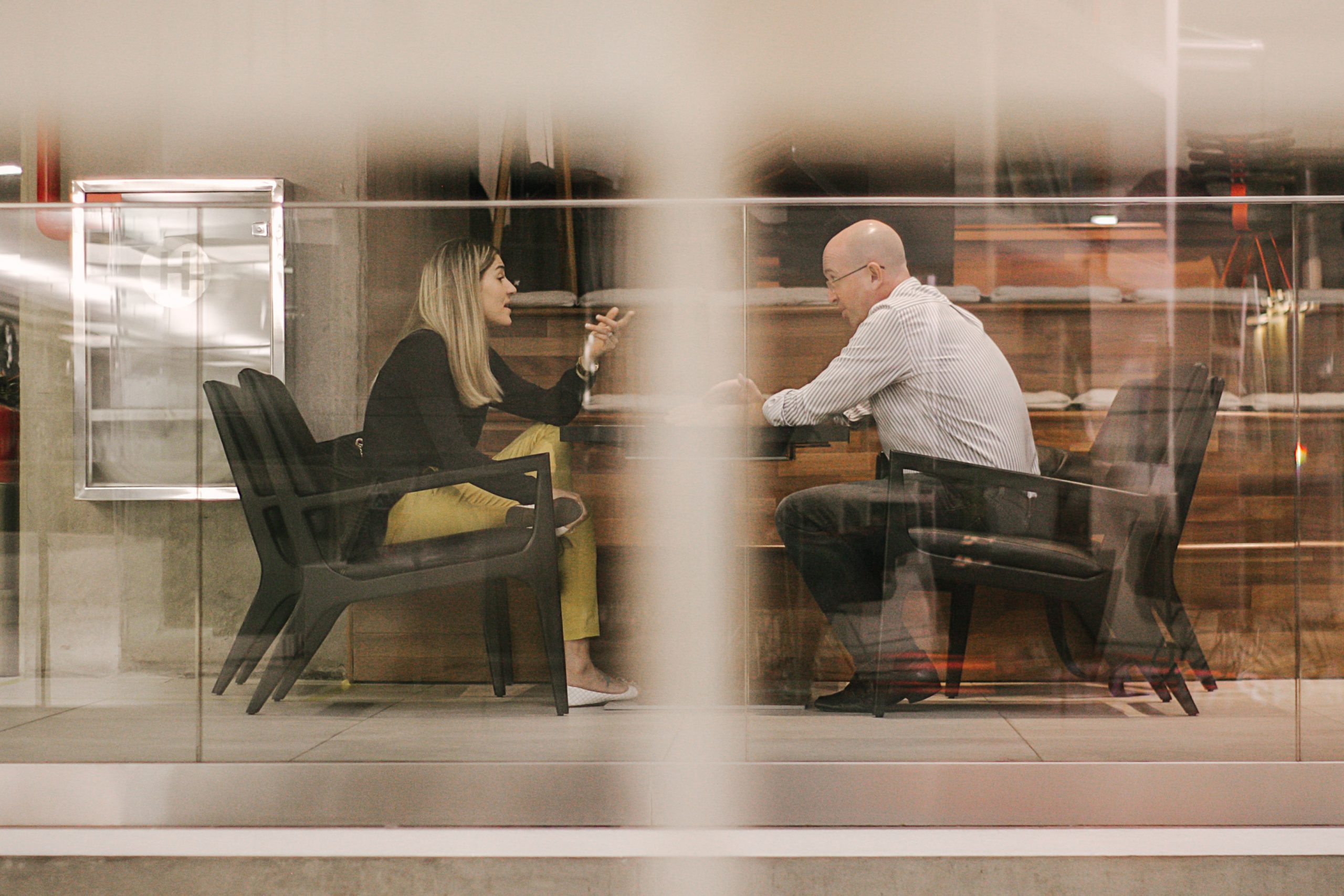 Two employees speaking across a table.